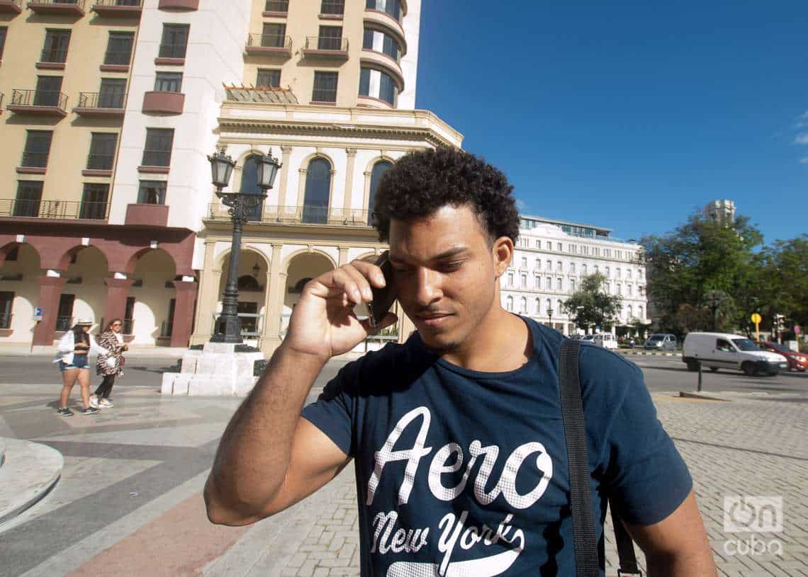A young man talking on a cell phone in the street. Photo: Otmaro Rodriguez.