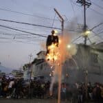 Residents burn a hanging "Judas" with a sign in Spanish that reads, "The Corrupt," in Caracas, Venezuela, April 9, 2023. Photo: AP/Ariana Cubillos.