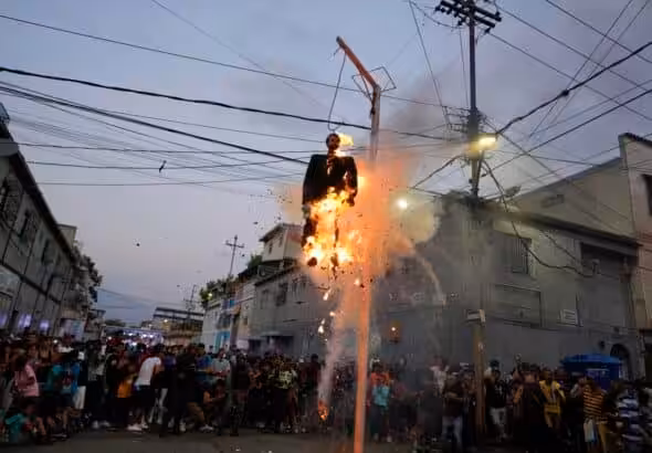 Residents burn a hanging "Judas" with a sign in Spanish that reads, "The Corrupt," in Caracas, Venezuela, April 9, 2023. Photo: AP/Ariana Cubillos.