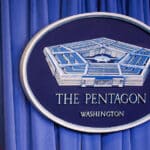 US flag next to a Pentagon emblem. Photo: Yasin Ozturk/Anadolu Agency/Gettyimages.ru.