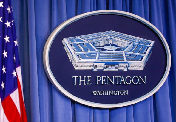US flag next to a Pentagon emblem. Photo: Yasin Ozturk/Anadolu Agency/Gettyimages.ru.