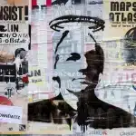 Street poster wall in Germany with a stencil of Julian Assange with an halo. Photo: Herder3 /CC BY-SA 3.0.