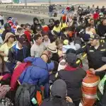 Peruvian police near the southern city of Tacna push back migrants of various nationalities who remain stranded in the no-man's land on the Peru-Chile border, April 26, 2023. Photo: Javier Rumiche/AFP.