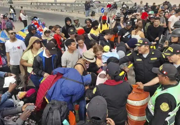 Peruvian police near the southern city of Tacna push back migrants of various nationalities who remain stranded in the no-man's land on the Peru-Chile border, April 26, 2023. Photo: Javier Rumiche/AFP.