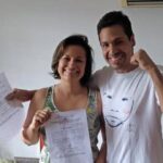 Former PDVSA executives Aryenis Torrealba and Alfredo Chirinos smiling and raising their fists while showing the judicial notification granting them full freedom. Photo: Social media.