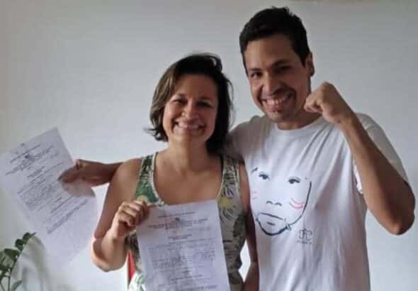 Former PDVSA executives Aryenis Torrealba and Alfredo Chirinos smiling and raising their fists while showing the judicial notification granting them full freedom. Photo: Social media.