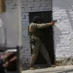 A police officer aims and shoots his firearm. Photo: AP.