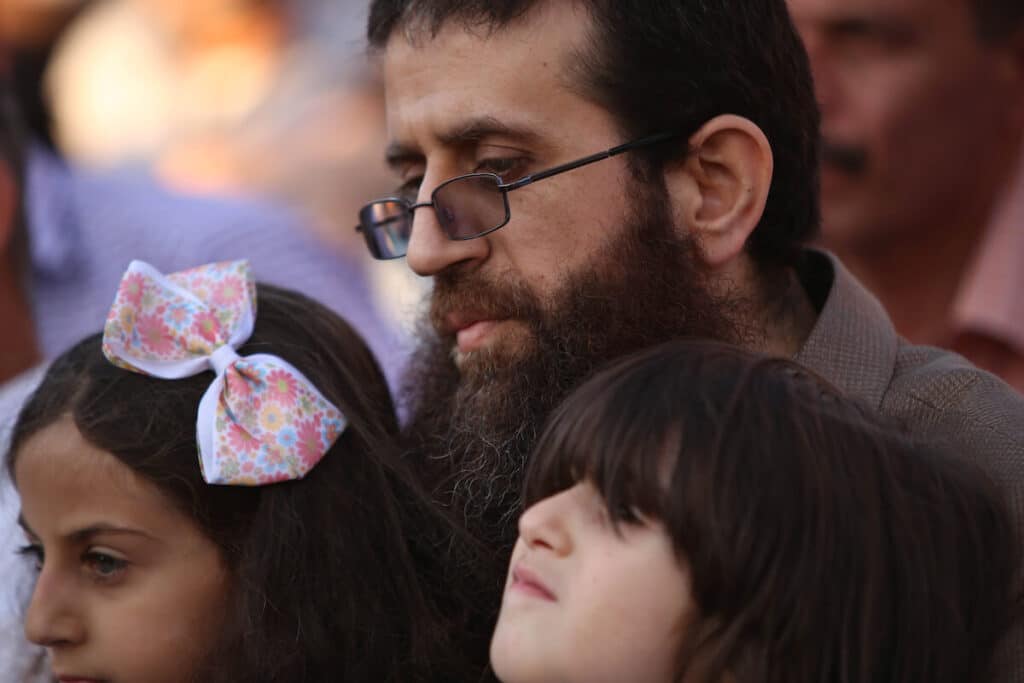 Khader Adnan with his children during a rally in the Jenin town of Arrabeh honoring him following his release from Israeli prisons, July 12, 2015. Adnan would later die in Israeli custody on May 2, 2023, while nearing his 90th day on hunger strike protesting his imprisonment. Photo: Ahmad Talat/APA Images.