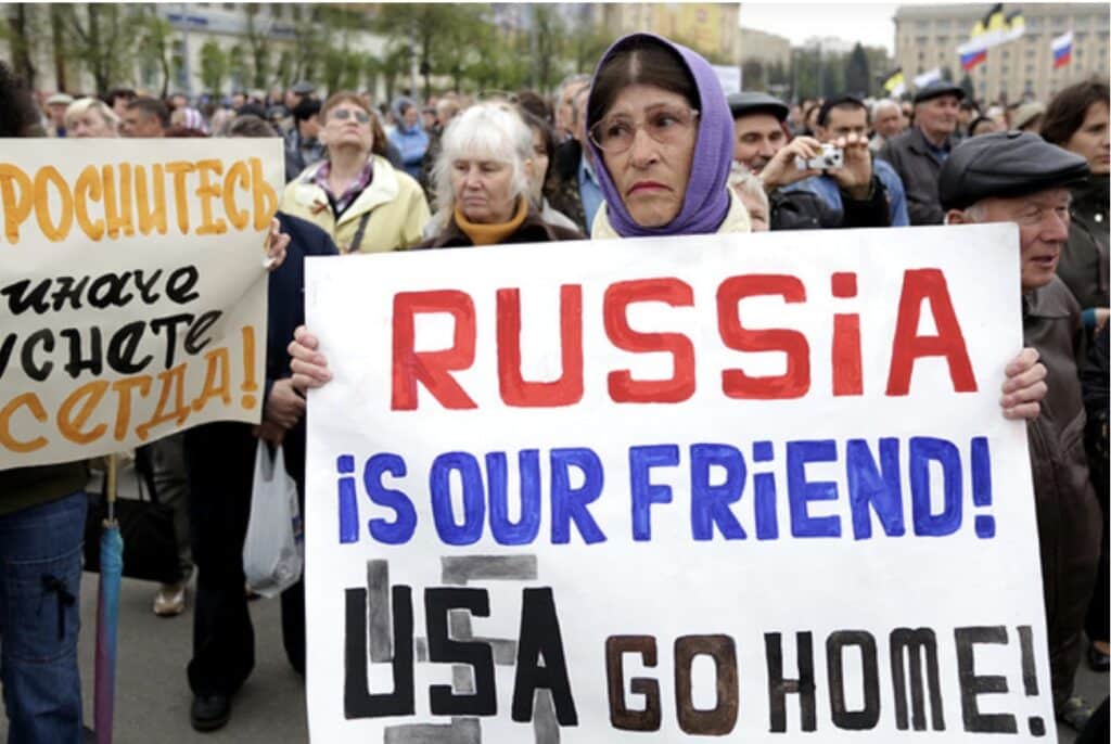 A woman holds a poster which reads \"Russia is our friends, USA do home\" during a pro-Russian rally in Kharkiv on April 21. Photo: Anastasia Vlasova.