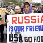 A woman holds a poster which reads \"Russia is our friends, USA do home\" during a pro-Russian rally in Kharkiv on April 21. Photo: Anastasia Vlasova.