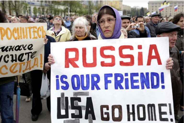A woman holds a poster which reads \"Russia is our friends, USA do home\" during a pro-Russian rally in Kharkiv on April 21. Photo: Anastasia Vlasova.