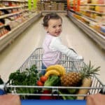 A baby on a shopping cart. Photo: Getty Images/Caroline Purser.