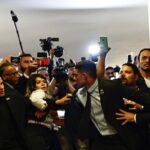 Featured image: Brazilian security agents containing the journalist that broke security restrictions in an attempt to create issues around Venezuelan President Nicolás Maduro's visit to Brasília. Photo: Instagram/@ueislermarcelinooficial.