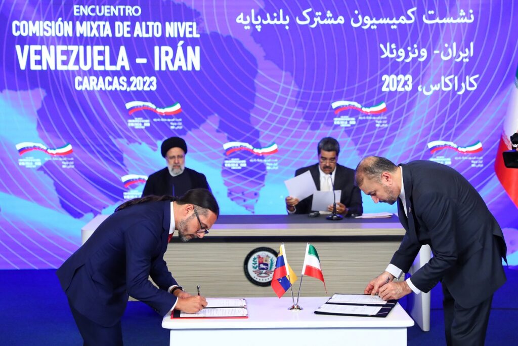 Venezuelan and Iranian minister for communication and information signing a bilateral agreement at Miraflores Palace in Caracas, with President Raisi and President Maduro in the background chairing the ceremony on Monday, June 12, 2023. Photo: Venezuela's Presidential Press.