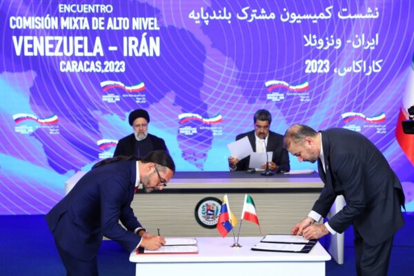 Venezuelan and Iranian minister for communication and information signing a bilateral agreement at Miraflores Palace in Caracas, with President Raisi and President Maduro in the background chairing the ceremony on Monday, June 12, 2023. Photo: Venezuela's Presidential Press.