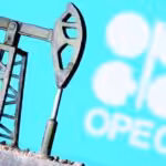 Miniature oil well with the OPEC logo in the background. File photo.