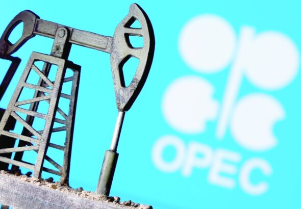 Miniature oil well with the OPEC logo in the background. File photo.