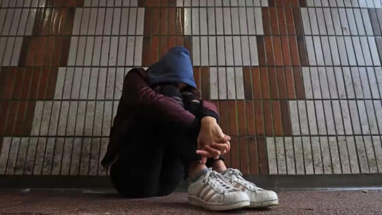 Child hunched over wearing a hoodie in front of a wall. Photograph: Gareth Fuller/PA Media.