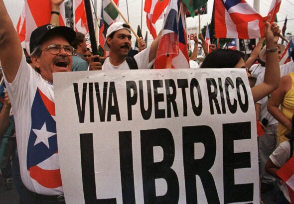 People protesting with Puerto Rican flags and holding a banner that reads "Viva Puerto Rico Libre." Photo: AP/File photo.