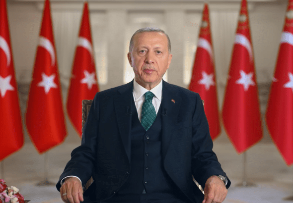 Turkish President Recep Tayyip Erdoğan with flags of Turkey in the background. File photo.