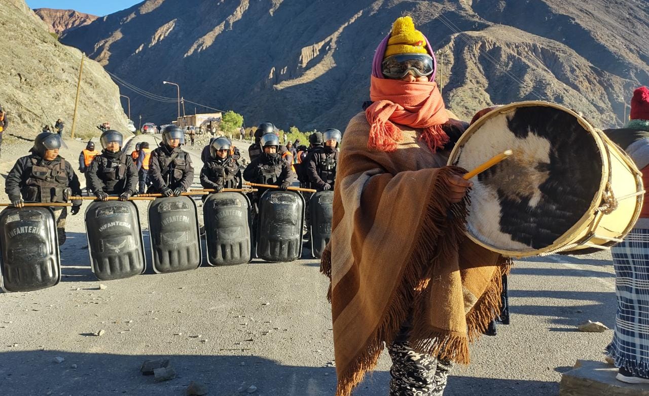 Indigenous woman in Jujuy playing drums in front of a police blockade as a sign of protest. Photo: Twitter/@PresentesLatam.