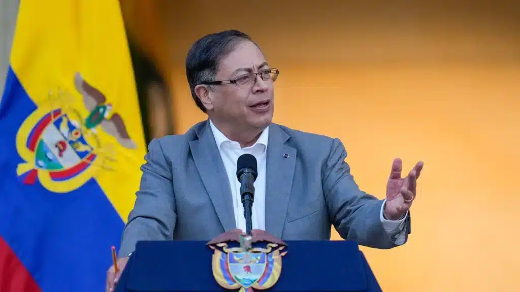 Colombian President Gustavo Petro standing in front of the flag of Colombia and giving a speech at a podium. File photo.