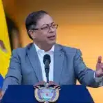 Colombian President Gustavo Petro standing in front of the flag of Colombia and giving a speech at a podium. File photo.