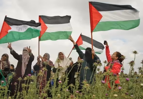 Palestinian women raising the Palestinian flag. File photo.