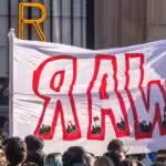 Protesters with a banner that reads "War". Photo: Edoardo Ceriani.