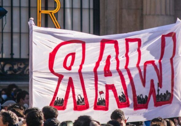 Protesters with a banner that reads "War". Photo: Edoardo Ceriani.