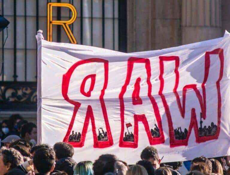 Protesters with a banner that reads "War". Photo: Edoardo Ceriani.