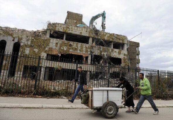 Pedestrians walk past the remains of the former Chinese Embassy in Belgrade, on November 10, 2010. In 1999, the Chinese embassy in Belgrade, was hit and set on fire during NATO airstrikes on the city. Photo: AFP 2023/Andrej Isakovic.