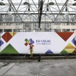 Worker cleaning a banner for the III EU-CELAC Summit. Photo: European Union.