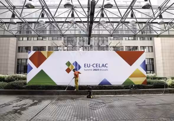 Worker cleaning a banner for the III EU-CELAC Summit. Photo: European Union.