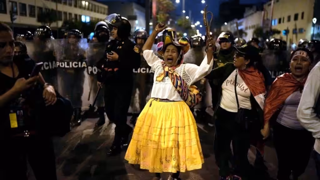 An opposition woman shouts in front of a police barricade during a march in downtown Lima, Peru, Wednesday, July 19, 2023. Protestors are demanding immediate early elections to Peruvian de facto ruler Dina Boluarte, as well as justice for those killed in the demonstrations that followed the parliamentary coup d'etat against President Castillo. Photo: AP/Rodrigo Abd.