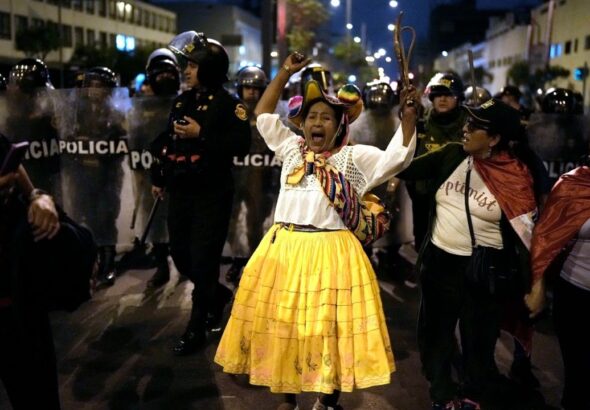 An opposition woman shouts in front of a police barricade during a march in downtown Lima, Peru, Wednesday, July 19, 2023. Protestors are demanding immediate early elections to Peruvian de facto ruler Dina Boluarte, as well as justice for those killed in the demonstrations that followed the parliamentary coup d'etat against President Castillo. Photo: AP/Rodrigo Abd.
