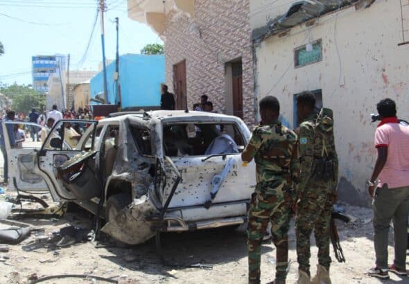 Troops look at a car bomb blast scene in Mogadishu, Somalia, January 2022. Photo: AFP/Getty Images.