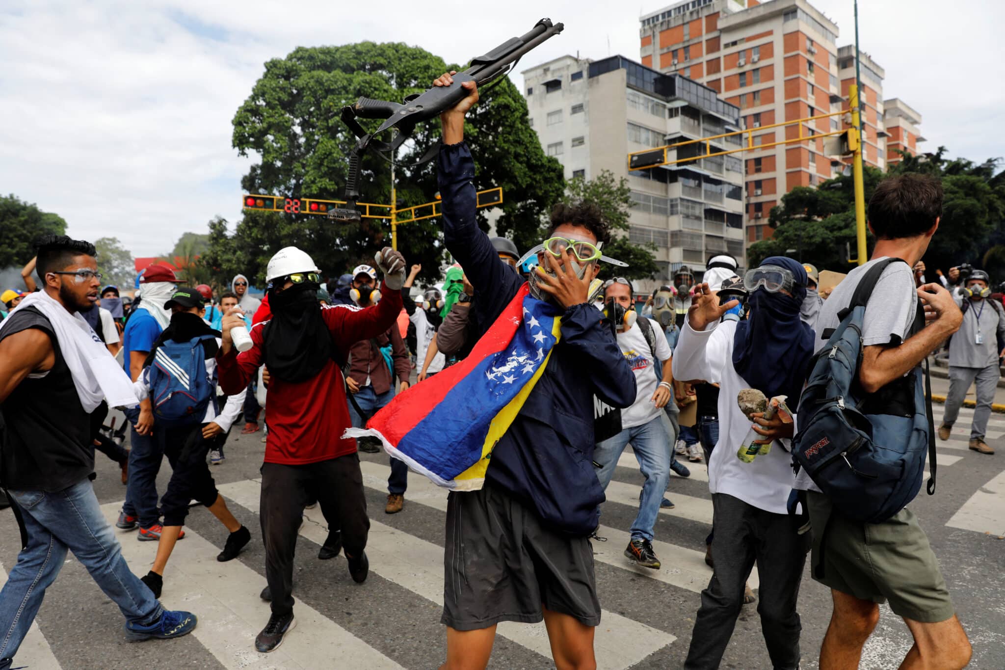 Opponents show a shotgun they snatched from police during a demonstration in Caracas, May 3, 2017. Photo: Carlos García Rawlins/Reuters.