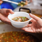 A person receiving a cup of soup in a street kitchen. Photo: File photo.