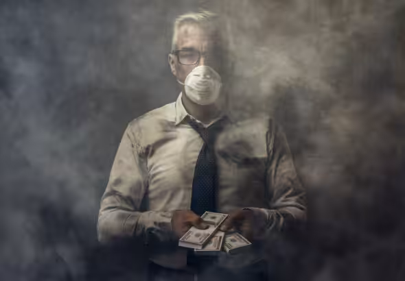 Business executive wearing a mask and holding cash banknotes. Photo: Getty Images.
