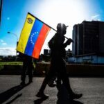 A PDVSA building and a Venezuelan flag. Photo: BBC.