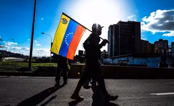 A PDVSA building and a Venezuelan flag. Photo: BBC.