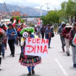A demonstrator holds a placard that says "Out Dina" during a protest demanding Peru's Unelected "President" Dina Boluarte to step down and reinstate democratic processes, in Cuzco, Peru February 2, 2023. Photo: Paul Gambin/Reuters.