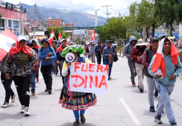 A demonstrator holds a placard that says "Out Dina" during a protest demanding Peru's Unelected "President" Dina Boluarte to step down and reinstate democratic processes, in Cuzco, Peru February 2, 2023. Photo: Paul Gambin/Reuters.
