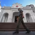 Man walking in front of the Venezuelan Red Cross headquarters in Caracas, on August 6, 2023. Photo: AFP.