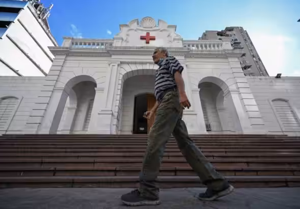 Man walking in front of the Venezuelan Red Cross headquarters in Caracas, on August 6, 2023. Photo: AFP.