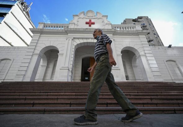 Man walking in front of the Venezuelan Red Cross headquarters in Caracas, on August 6, 2023. Photo: AFP.