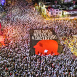 An aerial view shows protesters holding a sign with the silhouette of the face of Israeli Prime Minister Benjamin Netanyahu, as they take part in a demonstration against Israel's nationalist coalition government's judicial overhaul, in Tel Aviv, Israel May 6, 2023. Ilan Rosenberg/Reuters.
