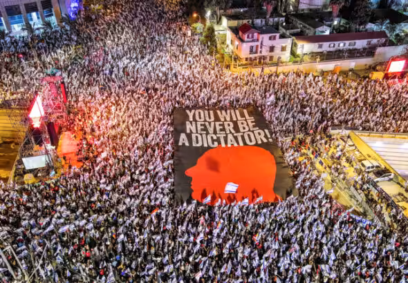 An aerial view shows protesters holding a sign with the silhouette of the face of Israeli Prime Minister Benjamin Netanyahu, as they take part in a demonstration against Israel's nationalist coalition government's judicial overhaul, in Tel Aviv, Israel May 6, 2023. Ilan Rosenberg/Reuters.