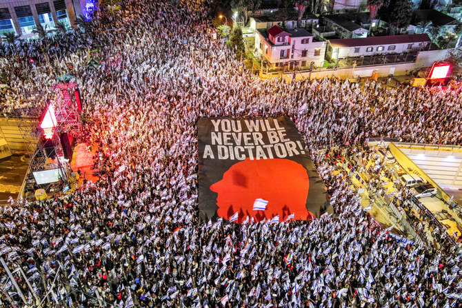 An aerial view shows protesters holding a sign with the silhouette of the face of Israeli Prime Minister Benjamin Netanyahu, as they take part in a demonstration against Israel's nationalist coalition government's judicial overhaul, in Tel Aviv, Israel May 6, 2023. Ilan Rosenberg/Reuters.